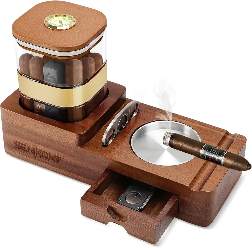 A walnut cigar humidor and ashtray set with a lit cigar resting in the tray