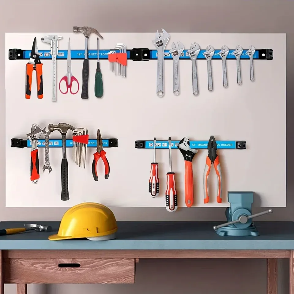 A magnetic tool bar mounted on the wall above a workbench