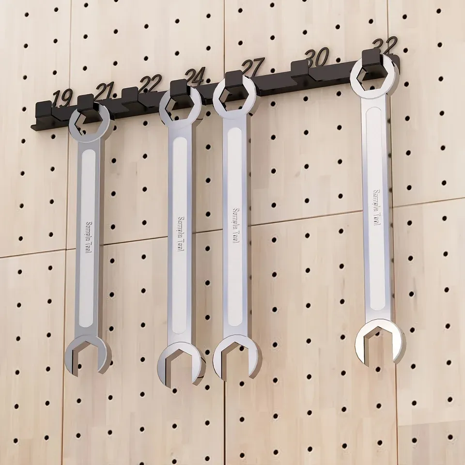 A numbered wall rail holding a graded row of spanners on a pegboard